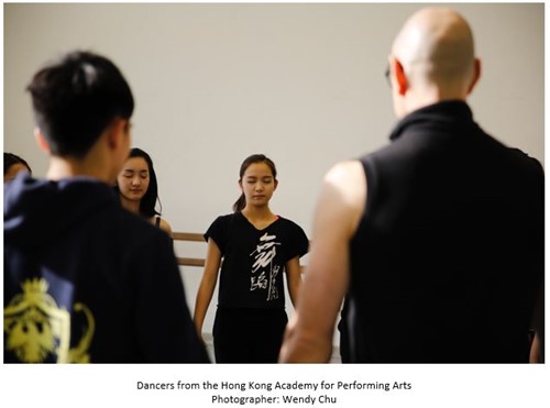 Dancers standing in a circle with their eyes closed