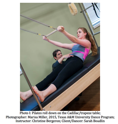 A dancer doing a pilates roll on a machine